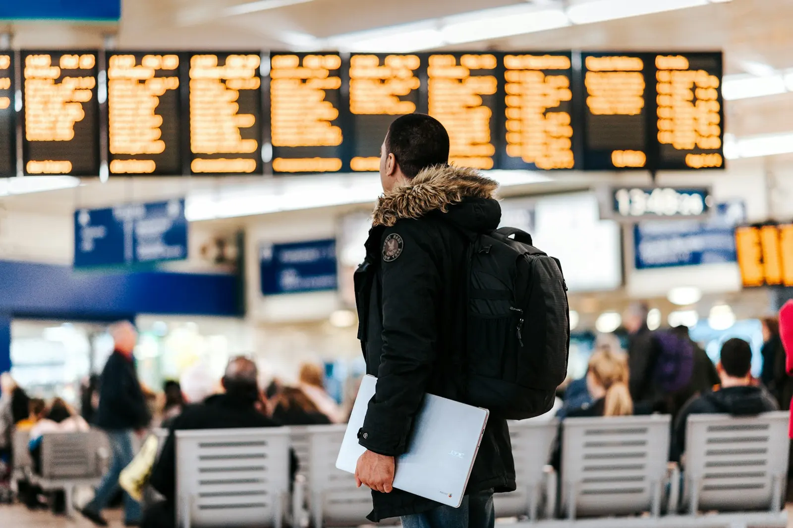 Bir gezgin tren istasyonunda sefer tahtasına bakıyor